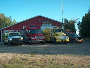Four fire rescue vehicles parked outside of a fire station